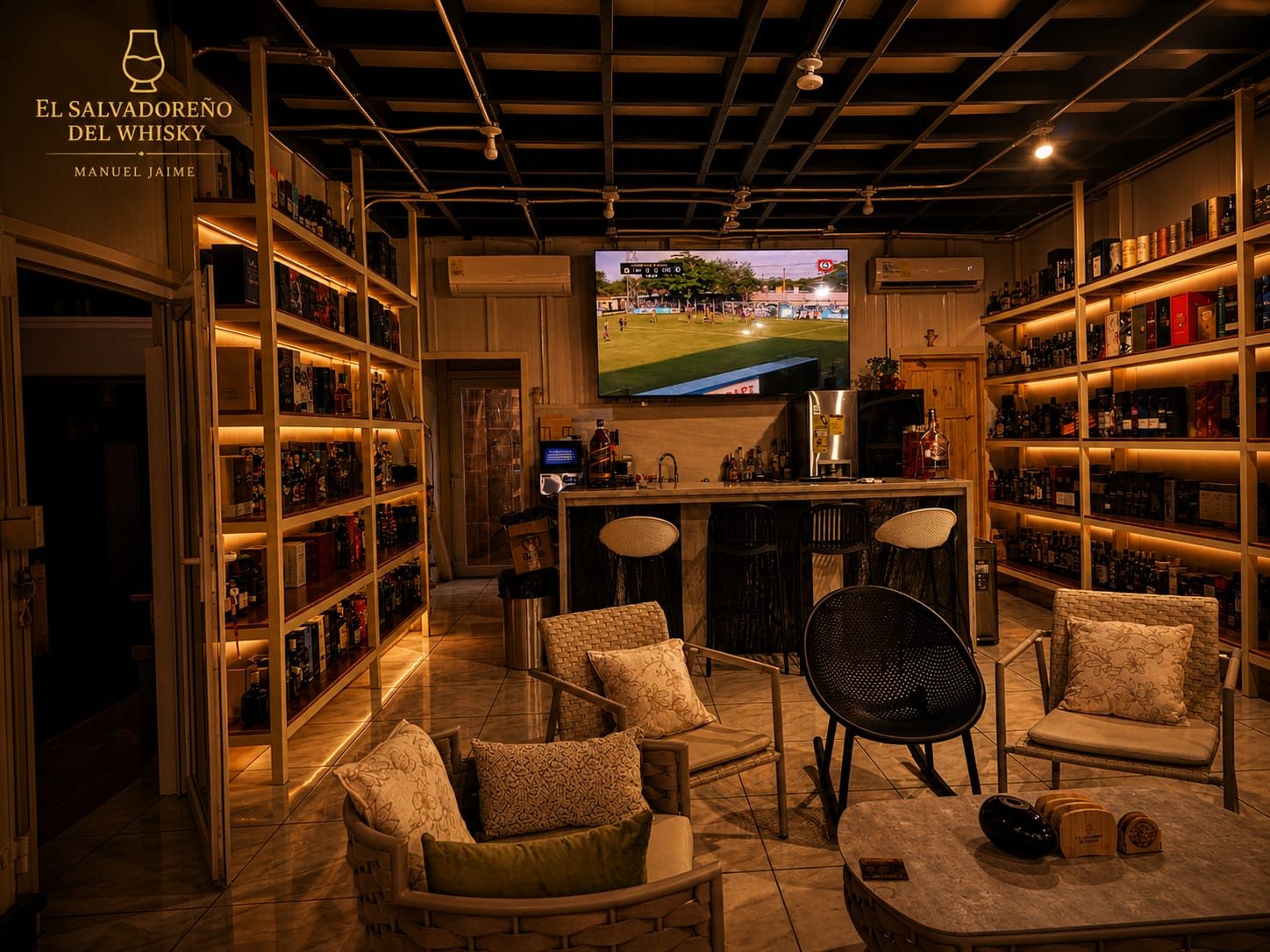 Vista principal del lounge de la cava El Salvadoreño del Whisky · paredes de estantes iluminados, bar y zona de degustación